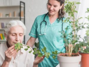 nurse-looking-senior-female-patient-smelling-ivy-plant-pot_23-2147861507.jpg