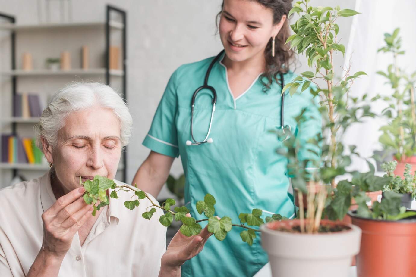 nurse-looking-senior-female-patient-smelling-ivy-plant-pot_23-2147861507.jpg
